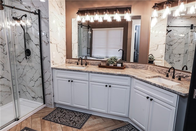 bathroom featuring a shower with door and vanity