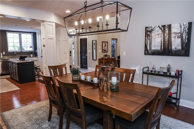 dining room featuring wood-type flooring and decorative columns