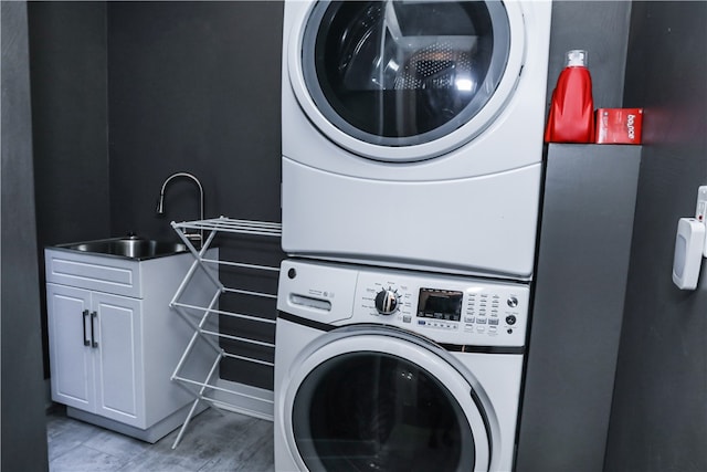 laundry room featuring stacked washer / dryer and sink