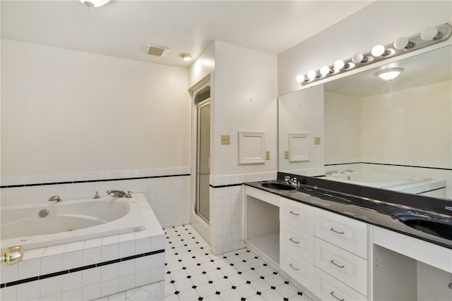 bathroom featuring shower with separate bathtub and vanity