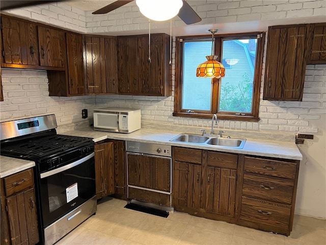 kitchen with dark brown cabinets, stainless steel gas range oven, and sink