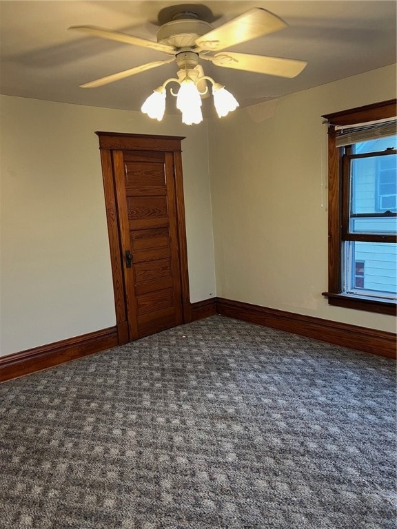 unfurnished room featuring dark carpet and ceiling fan