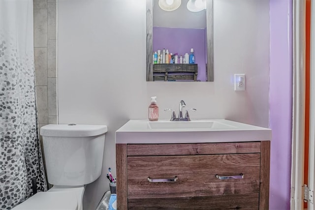 bathroom with walk in shower, vanity, and toilet