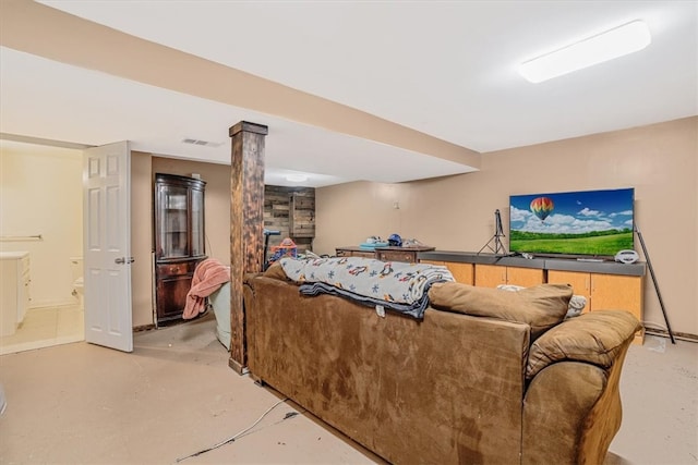 living room featuring concrete flooring and decorative columns