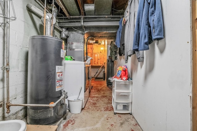 utility room featuring water heater and washer / dryer