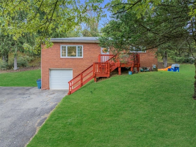 view of front of house with a wooden deck, a front lawn, and a garage