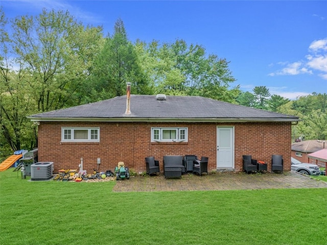 back of property with a lawn and central AC