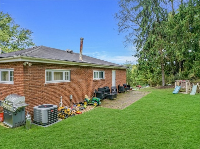 rear view of property featuring a lawn, a playground, central AC unit, and a patio area