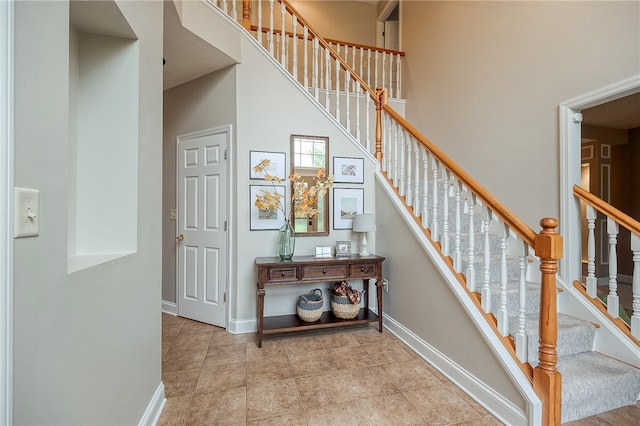 stairs featuring a towering ceiling and tile patterned floors