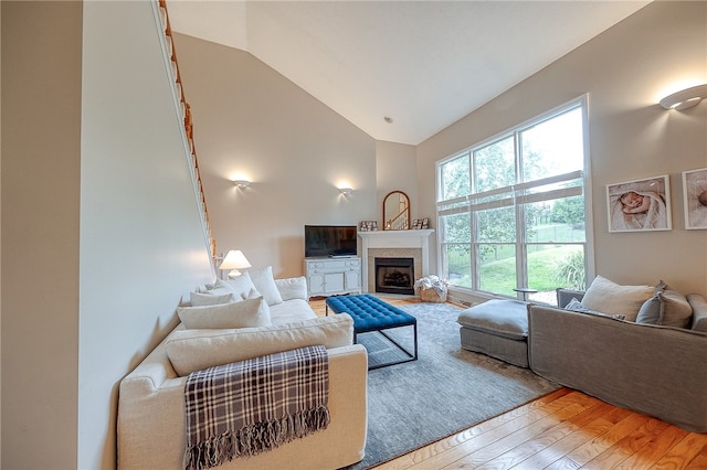 living room with hardwood / wood-style floors and high vaulted ceiling