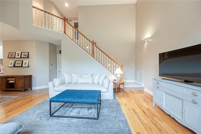 living room featuring light hardwood / wood-style floors and high vaulted ceiling