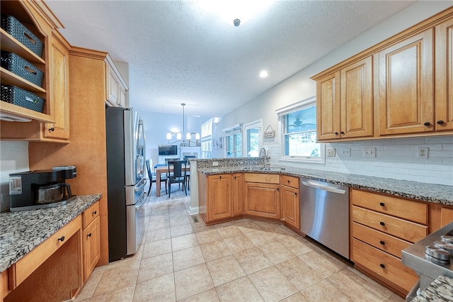 kitchen featuring stone counters, decorative backsplash, appliances with stainless steel finishes, light tile patterned floors, and decorative light fixtures