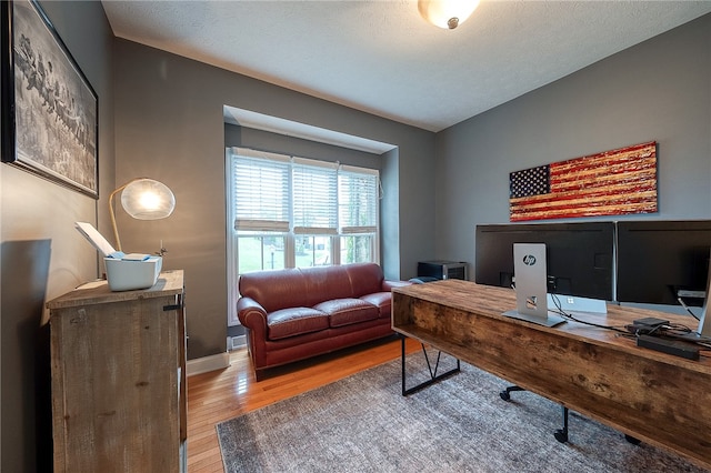 office with wood-type flooring and a textured ceiling