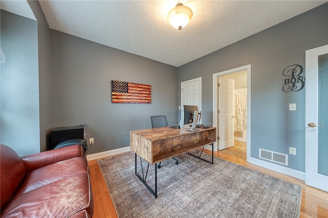 office with a textured ceiling and hardwood / wood-style floors