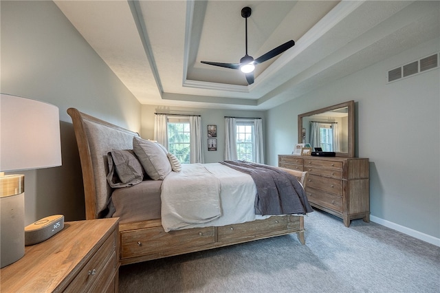 bedroom with carpet, a tray ceiling, and ceiling fan