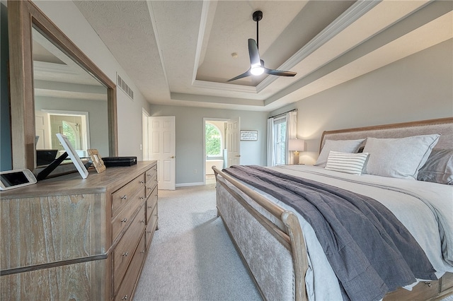 bedroom with light carpet, a tray ceiling, ceiling fan, and a textured ceiling