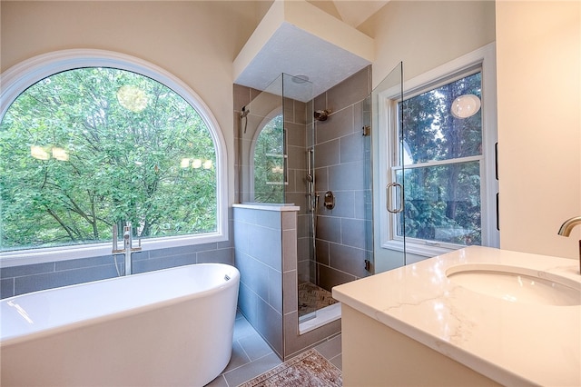 bathroom featuring a healthy amount of sunlight, independent shower and bath, vanity, and tile patterned floors