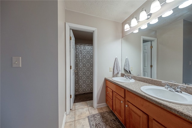 bathroom with a textured ceiling, vanity, a shower with shower curtain, and tile patterned floors