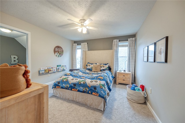 carpeted bedroom with ceiling fan and a textured ceiling