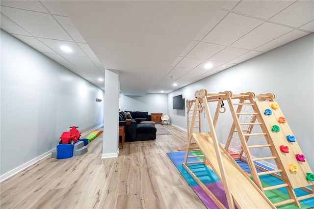 playroom with wood-type flooring and a drop ceiling