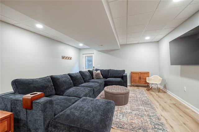 living room with a drop ceiling and hardwood / wood-style floors