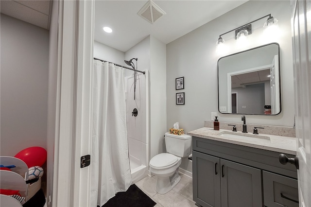 bathroom with walk in shower, vanity, tile patterned flooring, and toilet