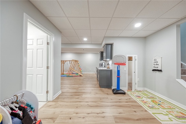 playroom featuring light wood-type flooring and a drop ceiling