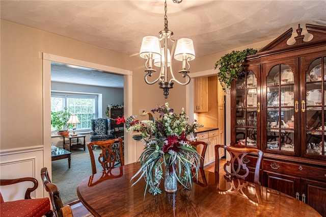 dining room with a textured ceiling, hardwood / wood-style floors, and an inviting chandelier