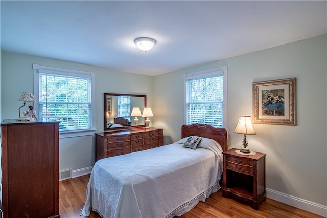 bedroom featuring light wood-type flooring and multiple windows