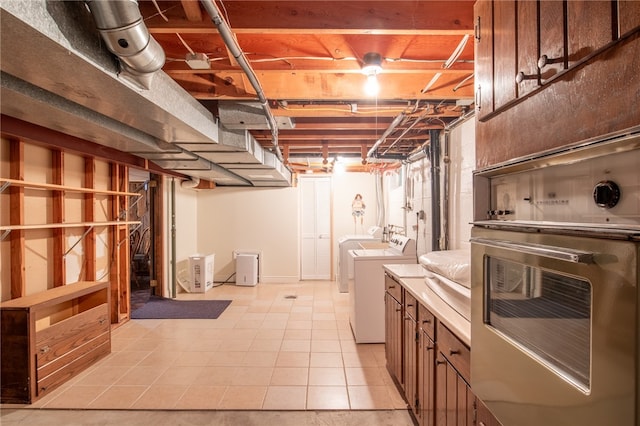 basement featuring light tile patterned flooring and separate washer and dryer