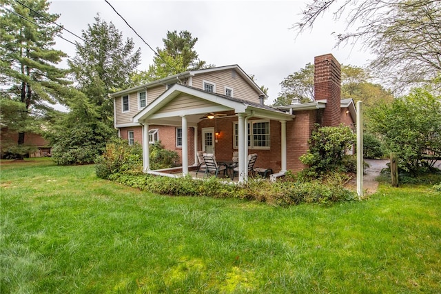 rear view of property featuring ceiling fan, a lawn, and a patio area