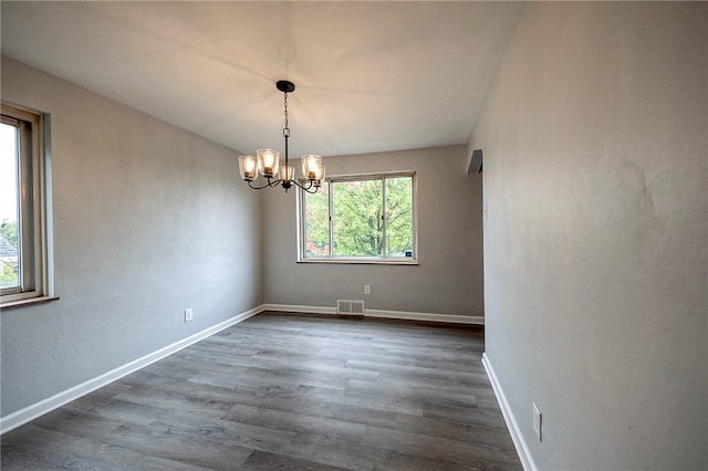 empty room featuring dark hardwood / wood-style floors and a chandelier