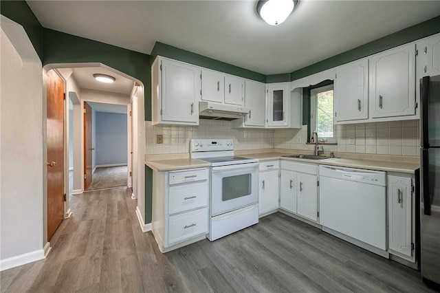 kitchen with sink, tasteful backsplash, white appliances, white cabinetry, and light hardwood / wood-style floors