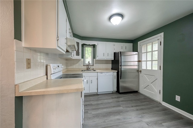 kitchen featuring white cabinets, white appliances, a wealth of natural light, and sink