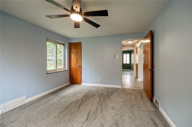 empty room featuring ceiling fan and light carpet