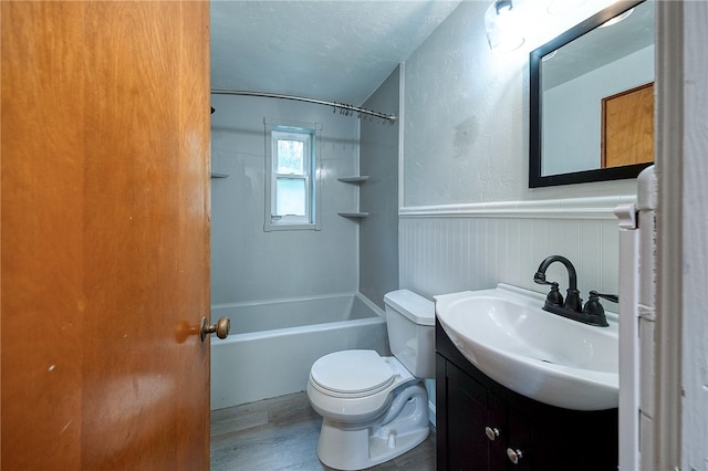 full bathroom featuring vanity, a textured ceiling, shower / bathtub combination, hardwood / wood-style floors, and toilet