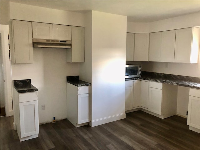 kitchen with dark hardwood / wood-style floors and white cabinets