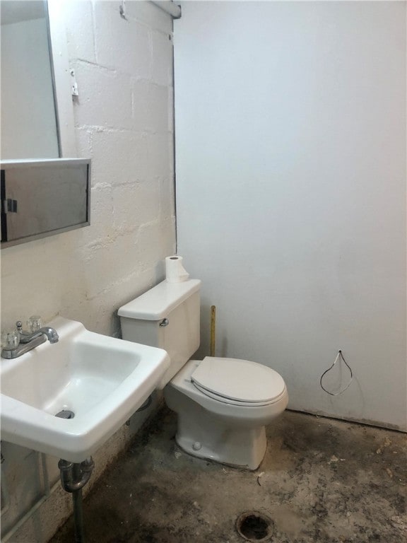 bathroom with concrete floors and toilet