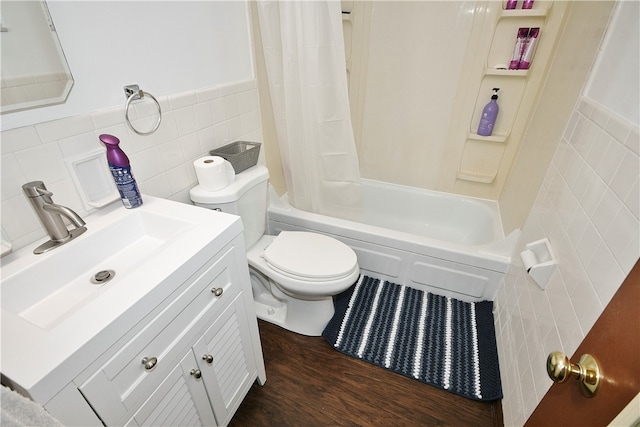 full bathroom with tile walls, shower / bath combo with shower curtain, vanity, toilet, and hardwood / wood-style floors