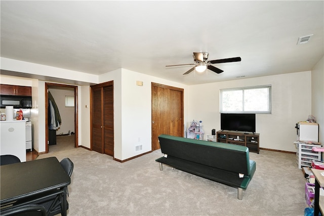 living room with ceiling fan and light colored carpet