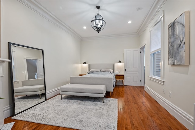 bedroom featuring hardwood / wood-style flooring, a notable chandelier, and ornamental molding