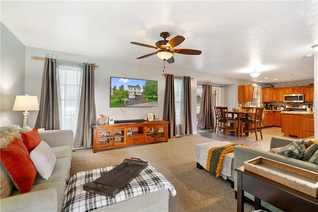 living room with ceiling fan and light colored carpet