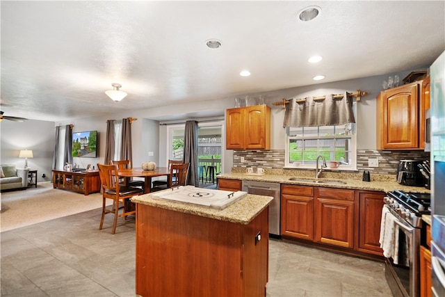 kitchen featuring appliances with stainless steel finishes, sink, tasteful backsplash, and a center island