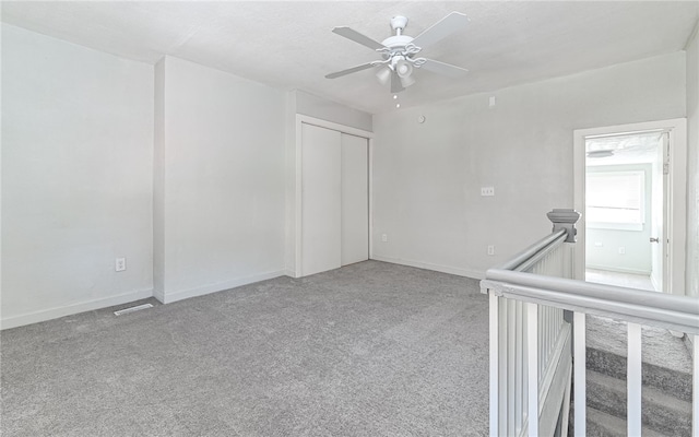 unfurnished room with ceiling fan and light carpet