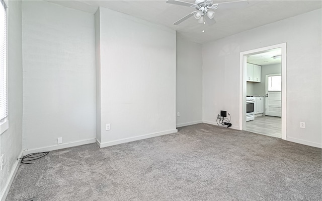 carpeted spare room featuring ceiling fan