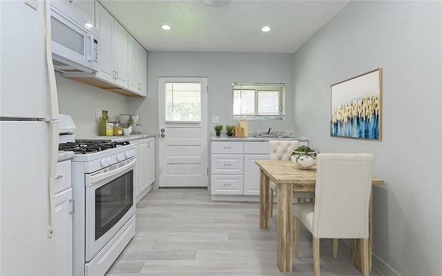 kitchen with white cabinetry, light wood-type flooring, white appliances, and sink