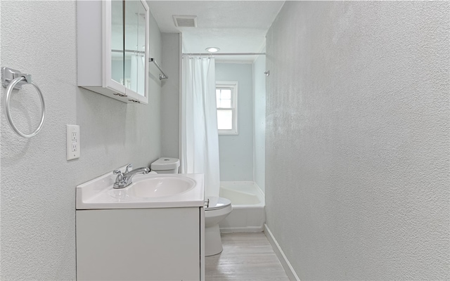 full bathroom featuring shower / bath combo, a textured ceiling, toilet, vanity, and hardwood / wood-style flooring