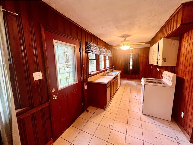 kitchen with wood walls, ceiling fan, and white range with electric stovetop