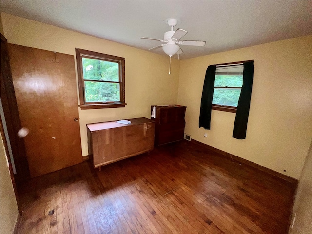 unfurnished room with ceiling fan, dark hardwood / wood-style floors, and a healthy amount of sunlight