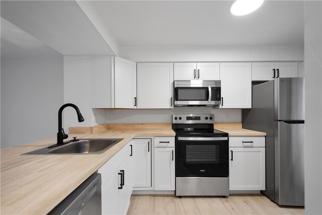 kitchen featuring white cabinetry, light hardwood / wood-style floors, appliances with stainless steel finishes, and sink